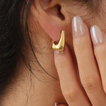 Geometric gold hoop earrings, detail view