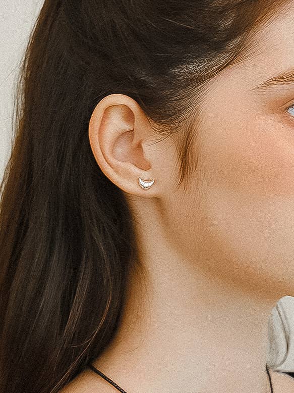 Petite sculptural stud earrings crafted from a brass base with premium 18K gold or silver plating, featuring a modern croissant-inspired design. Minimalist and Parisian-chic—perfect for adding a stylish twist to any everyday look. Hypoallergenic, water- and tarnish-resistant.