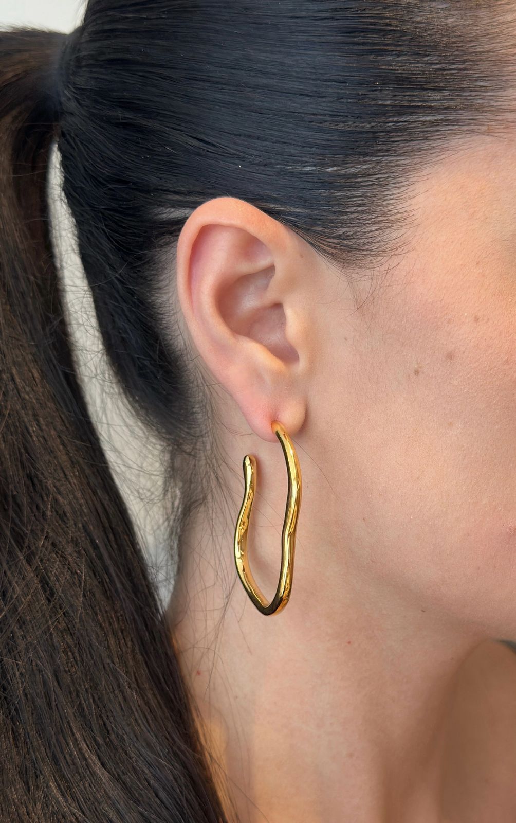 Curved hoop earrings crafted from 18K gold-plated stainless steel, featuring a unique sculptural silhouette that blends bold style with refined elegance. Hypoallergenic, water- and tarnish-resistant—perfect for making a statement from day to night.