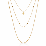 Gold necklace with three star pendants, worn