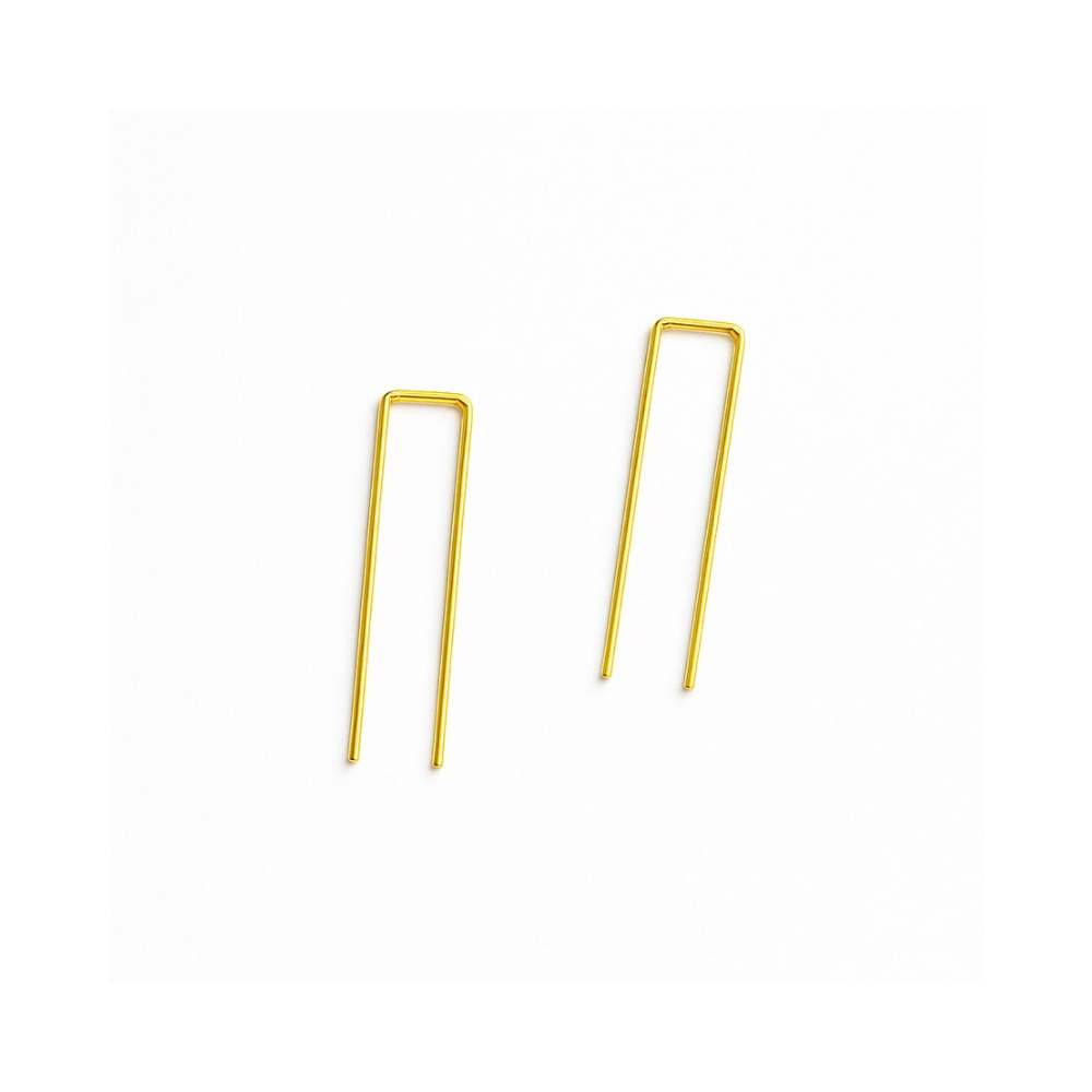 Gold metal hairpin clips on a white background