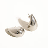Oversized droplet huggie earrings crafted with a smooth, sculpted finish for a bold yet elegant look. Hypoallergenic, water- and tarnish-resistant—perfect for elevating both everyday outfits and special occasion styles with modern sophistication.