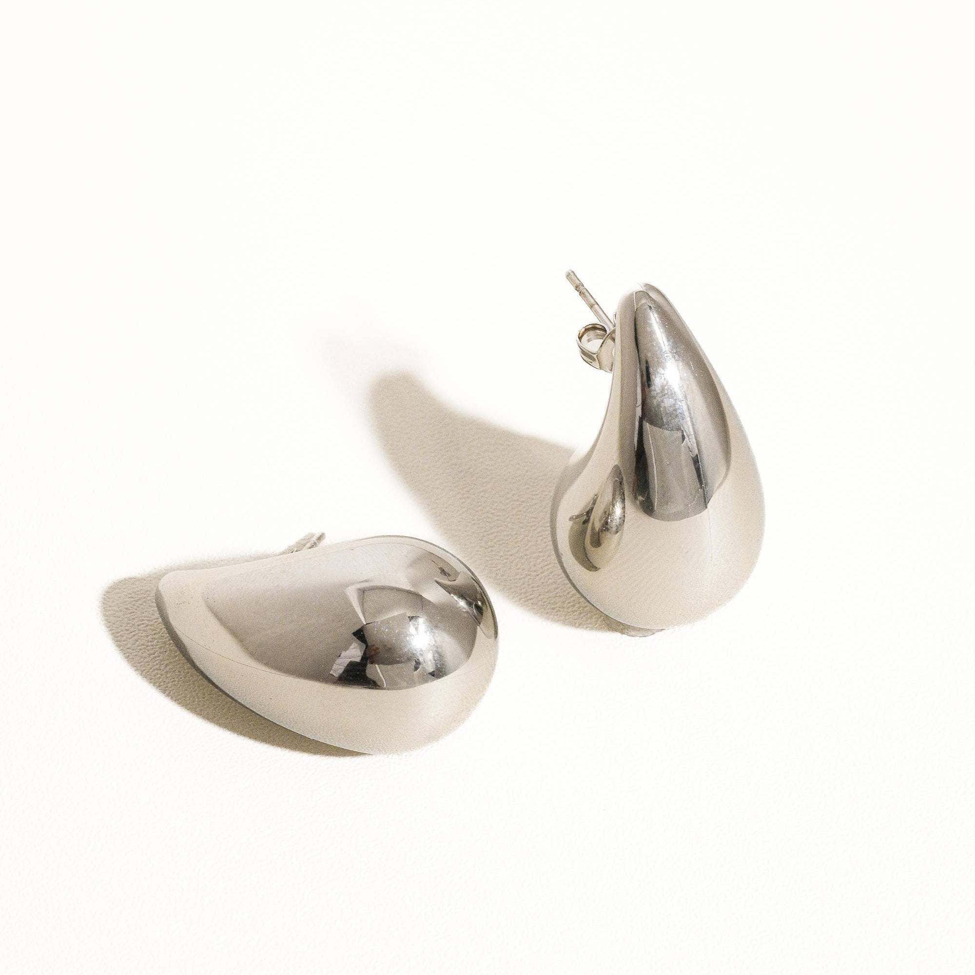 Oversized droplet huggie earrings crafted with a smooth, sculpted finish for a bold yet elegant look. Hypoallergenic, water- and tarnish-resistant—perfect for elevating both everyday outfits and special occasion styles with modern sophistication.