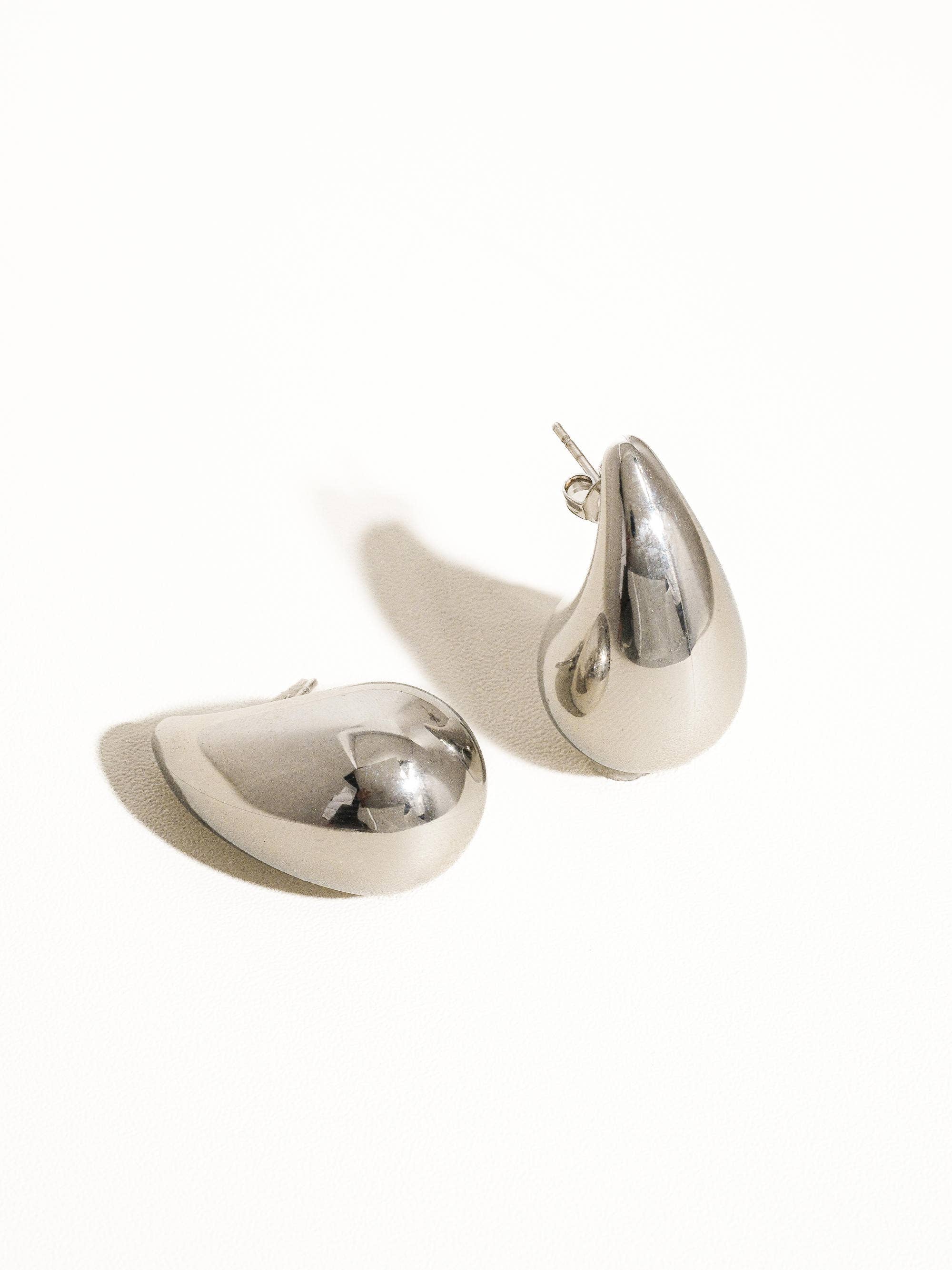Oversized droplet huggie earrings crafted with a smooth, sculpted finish for a bold yet elegant look. Hypoallergenic, water- and tarnish-resistant—perfect for elevating both everyday outfits and special occasion styles with modern sophistication.