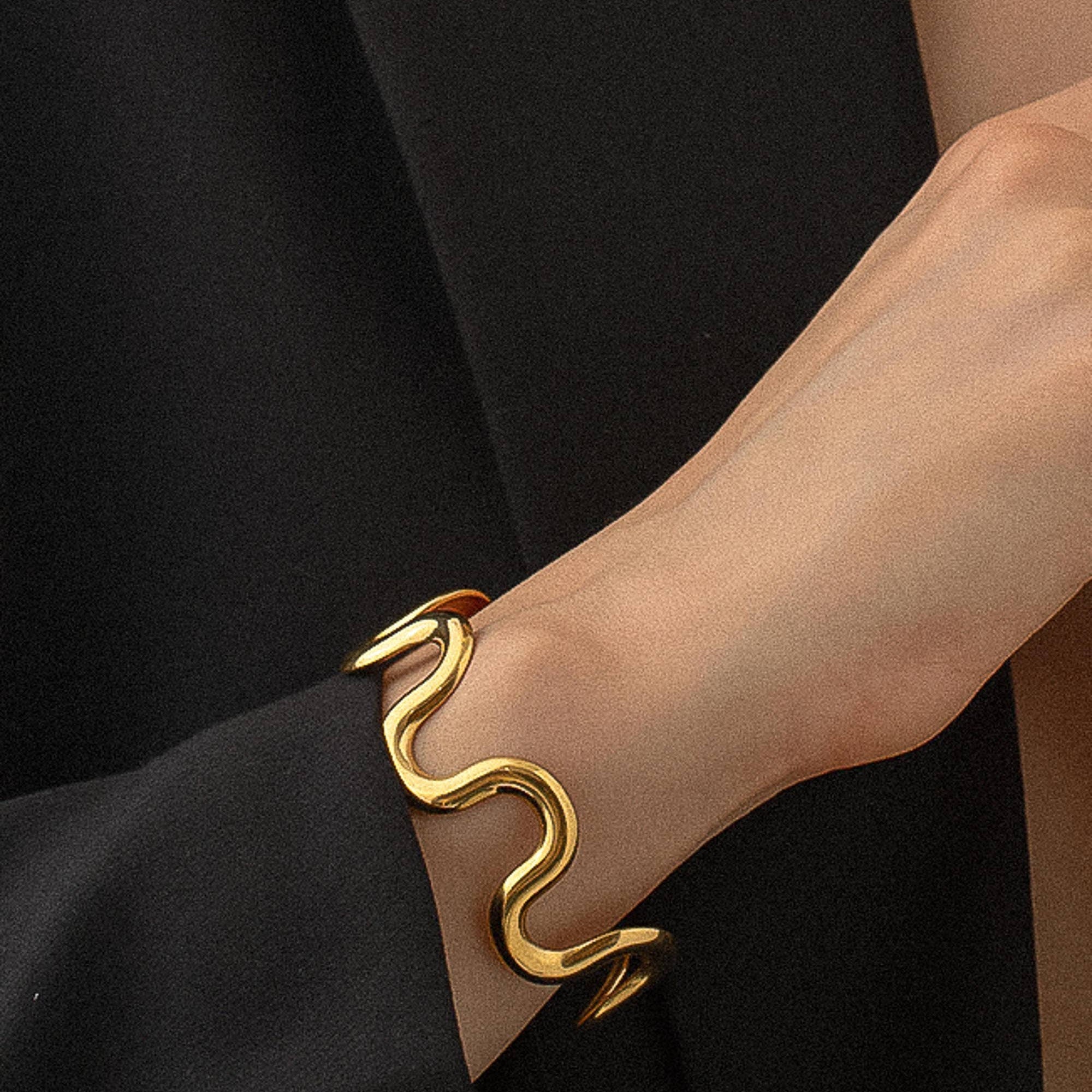 Sculptural statement cuff bracelet crafted from 18K gold-plated stainless steel, featuring a bold, organic wavy silhouette for modern elegance. Hypoallergenic, water- and tarnish-resistant—perfect for adding effortlessly chic style to any outfit.