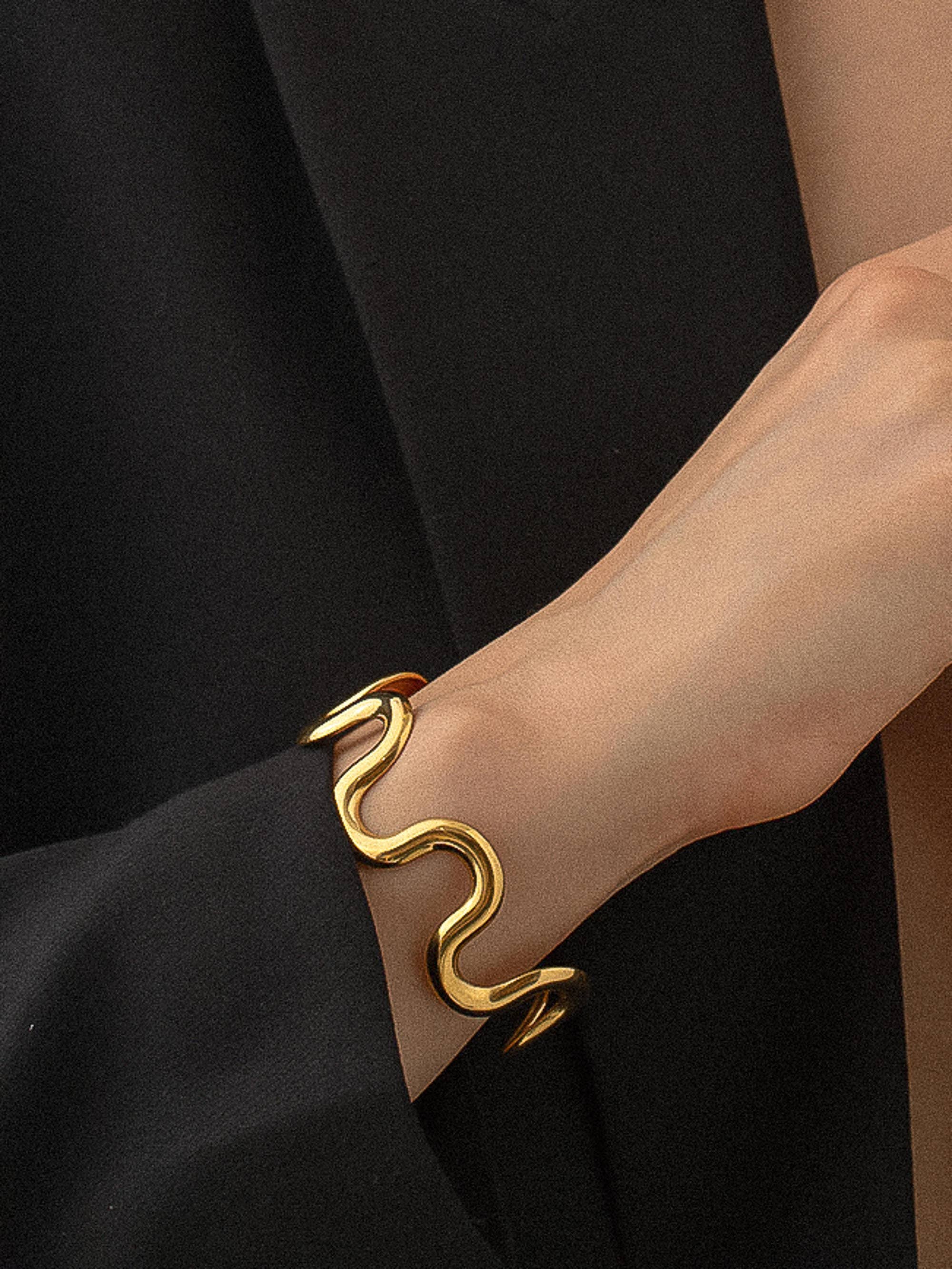 Sculptural statement cuff bracelet crafted from 18K gold-plated stainless steel, featuring a bold, organic wavy silhouette for modern elegance. Hypoallergenic, water- and tarnish-resistant—perfect for adding effortlessly chic style to any outfit.